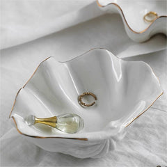 White ceramic shell craft product bowl with gold rim, elegant decorative dish for jewelry, snacks, or home decor.