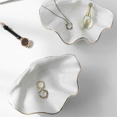 White shell craft product jewelry dish with wavy shell shape and gold rim, perfect for holding rings, necklaces, and accessories.