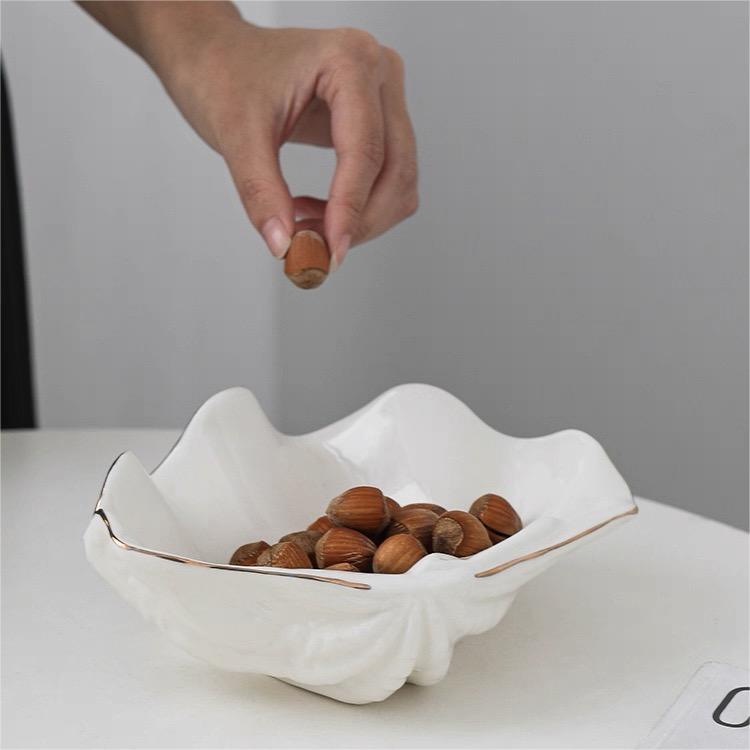 Elegant white shell craft product bowl used as a stylish snack dish for nuts, fruits, or candies on a modern table.