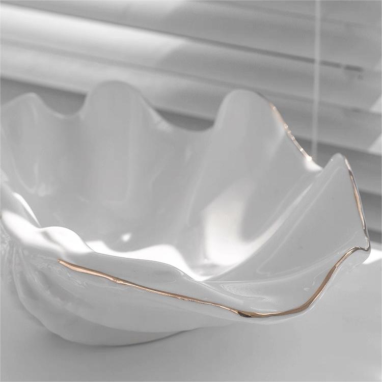 Minimalist white shell craft product bowl with delicate gold trim, stylish decorative tray for rings, earrings, or small items.