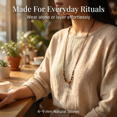 Woman wearing long Tiger Eye crystal necklace in neutral linen outfit